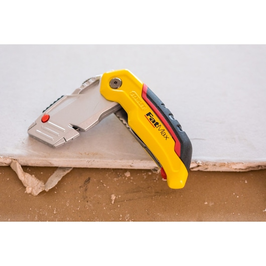 STANLEY 0-10-825 utility knife FatMax model on drywall, yellow and black ergonomic handle.
