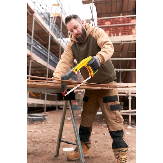STANLEY 0-20-108 hacksaw in use cutting metal rods at a construction site, product photography.