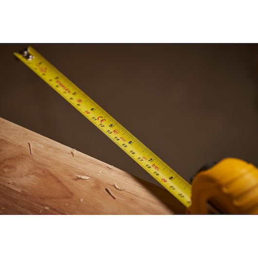 STANLEY 0-30-496 yellow tape measure on wood, close-up, photography of measuring tool.