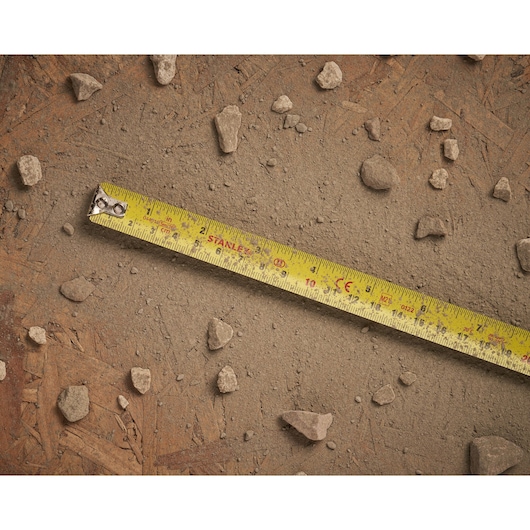 STANLEY 0-30-496 yellow tape measure on dusty ground with scattered rocks, photography
