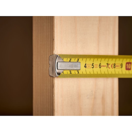 STANLEY 0-33-195 tape measure measuring wooden plank, close-up photography.