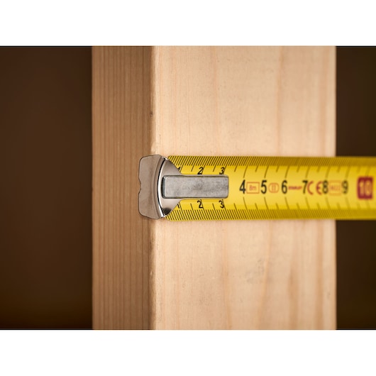 STANLEY 0-33-198 tape measure extended across wooden plank, close-up angle.