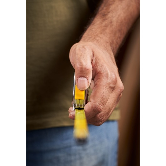 STANLEY 0-33-238 tape measure held in hand, front angle, yellow and silver, photography product close-up.