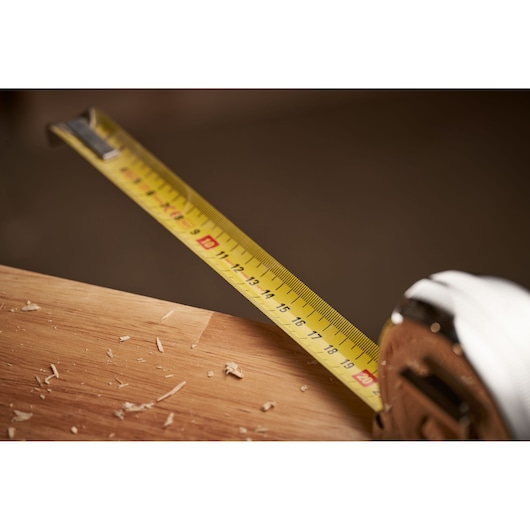 STANLEY 0-33-527 tape measure extended on wooden surface with wood shavings, close-up photography.