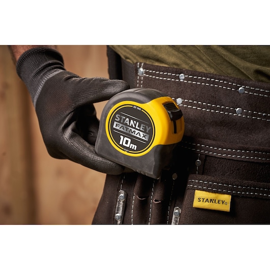 STANLEY 0-33-811 photography of yellow tape measure showing metric scale, close-up on dusty surface.
