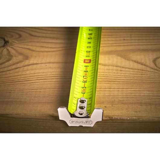 STANLEY 0-33-887 tape measure with yellow blade extended on wooden surface, close-up view.