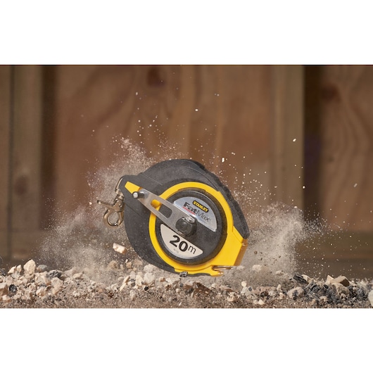 STANLEY 0-34-133 tape measure, 20m, black and yellow, shown on construction site with dust and rocks.