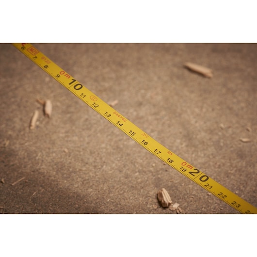 STANLEY 0-34-134 yellow measuring tape photography, close-up on sandy surface.