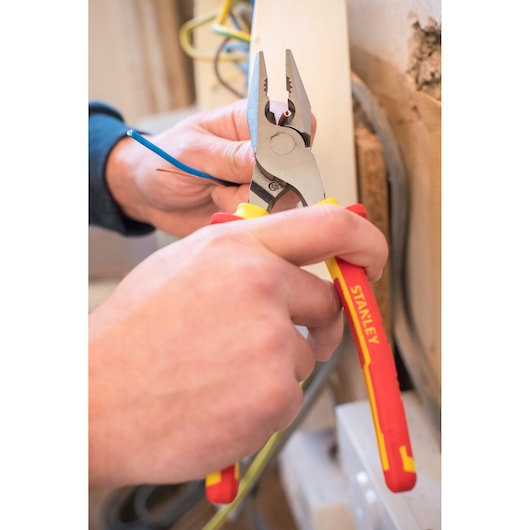 STANLEY 0-84-002 insulated pliers cutting electrical wire, close-up photography during installation.