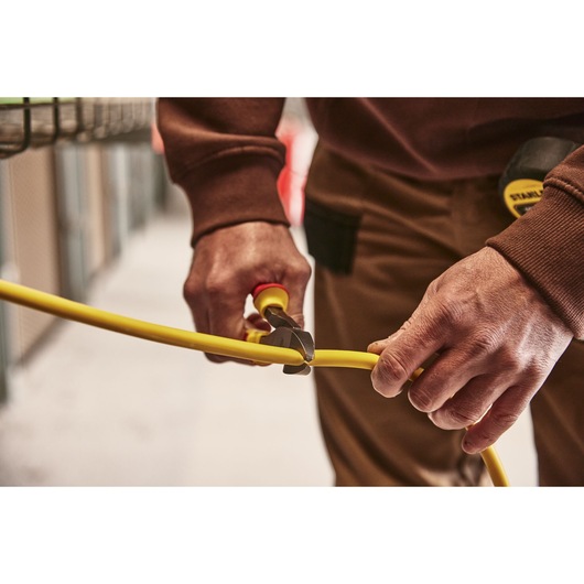 STANLEY 0-84-004 pliers cutting yellow cable in workshop setting, close-up photography.