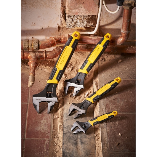 STANLEY 0-90-949 adjustable wrenches set, yellow and black handles, shown at a plumbing worksite.