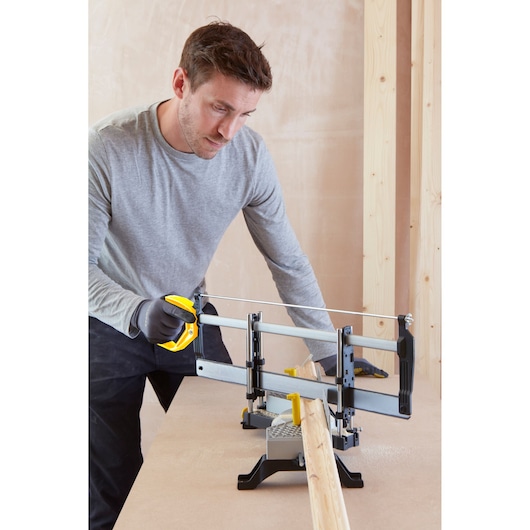 STANLEY 1-20-800 hand saw with mitre box on table, shown cutting wooden plank, side angle.