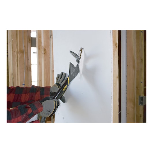 STANLEY 1-55-099 demolition tool used to break drywall, shown in a construction setting.