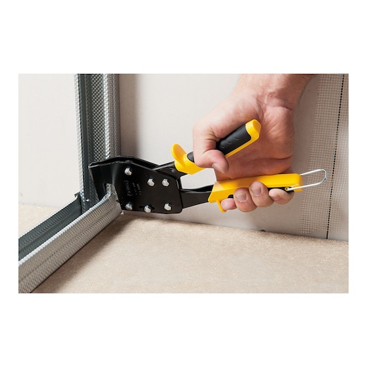 Photo of STANLEY 1-69-100 hand-operated metal pliers used on drywall corner frame, close-up angle.