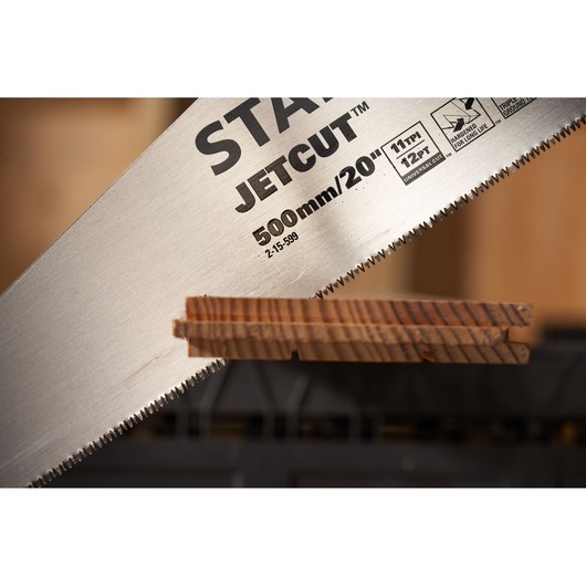 STANLEY 2-15-599 hand saw JetCut blade close-up cutting wood, photography side angle.