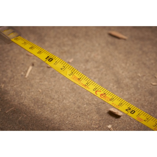 STANLEY 2-34-777 yellow measuring tape close-up on textured ground, photography