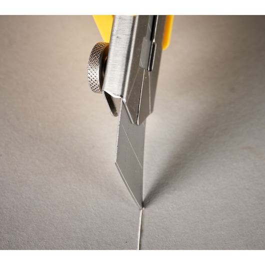 STANLEY 3-11-718 utility knife blade cutting cardboard, close-up angle.