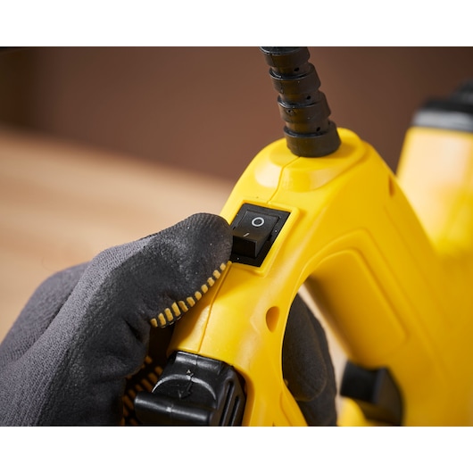 Photo of STANLEY 6-TRE550 yellow tool handle and power switch, close-up with glove.