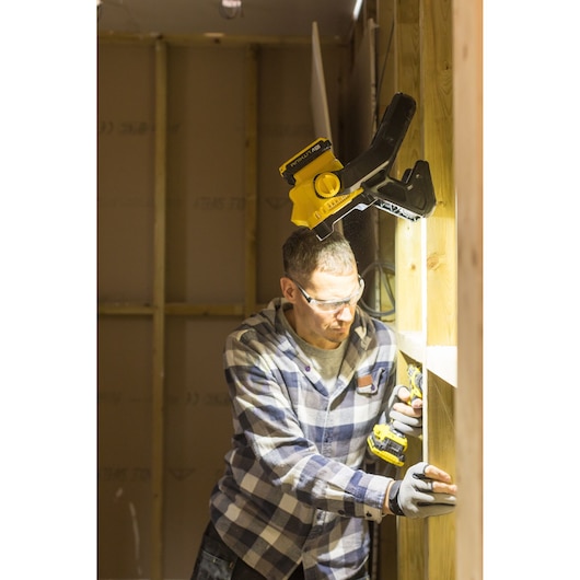 STANLEY FMCL001B work light clipped to wooden beam, illuminating worker using power drill.