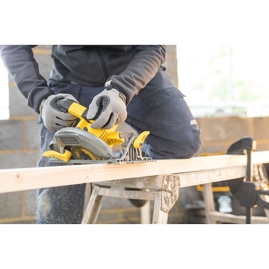 STANLEY FME301 circular saw used to cut wood, close-up side view shows gloved hands operating the tool.