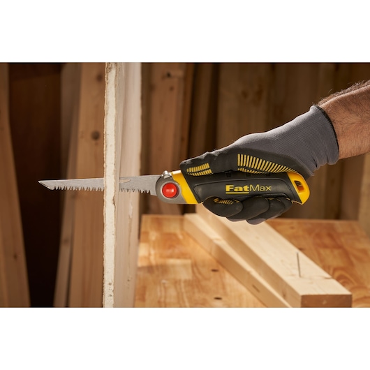 STANLEY FMHT0-20559 FatMax folding saw cutting drywall, close-up view in gloved hand.