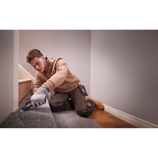 STANLEY FMHT10500-0 utility knife in use on carpet flooring, shown in home installation context.