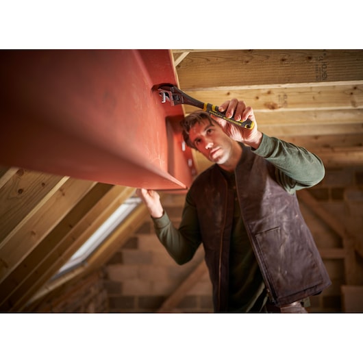 STANLEY FMHT13127-0 adjustable wrench used on a red steel beam in a loft construction setting.