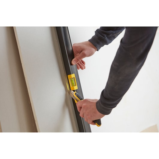 STANLEY FMHT42561-1 level tool with utility knife on drywall, close-up photography.