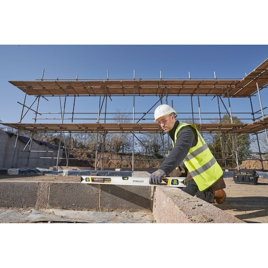 Photo of a worker using a STANLEY FMHT43675-1 spirit level on a construction site.