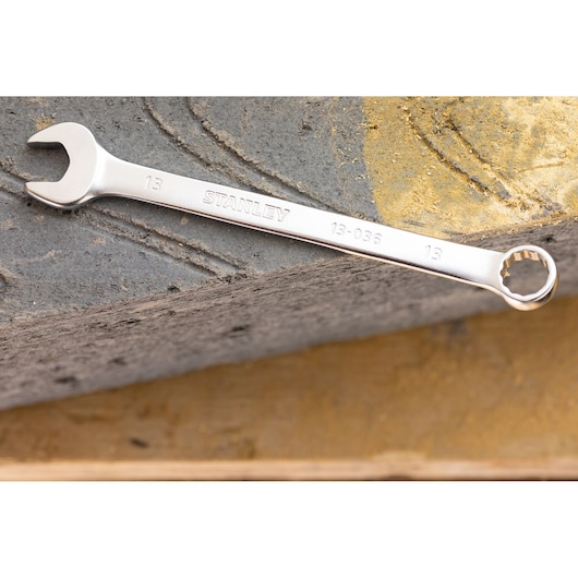 STANLEY FMMT13031-0 combination wrench with open and box ends on stone surface.