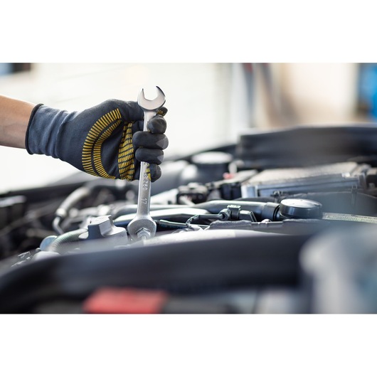 Photo of STANLEY FMMT13069-0 wrench in gloved hand tightening bolt in engine bay, tool category.