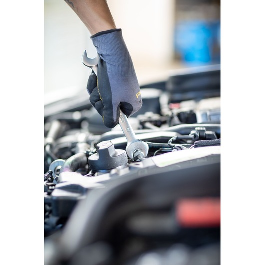 STANLEY FMMT13073-0 wrench in use on engine, mechanic wearing glove, close-up, photography.