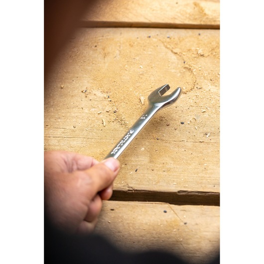 STANLEY FMMT13074-0 wrench held in hand, silver finish, on a wooden surface, close-up photography.
