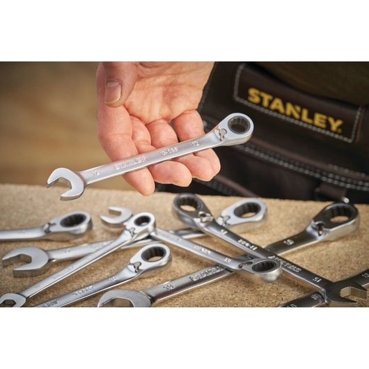 STANLEY FMMT13085-0 photography of silver ratcheting spanners held in hand, with tool belt and workbench.