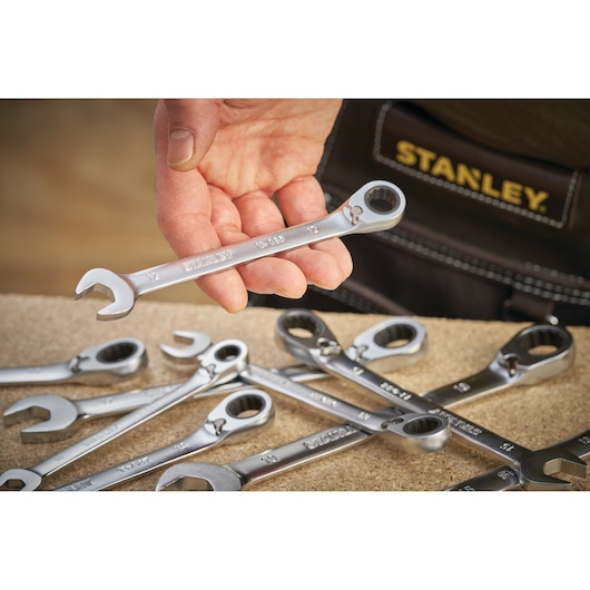 Photo of STANLEY FMMT13086-0 ratcheting spanner set held in hand, several wrenches on workbench.