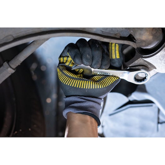 Photo of STANLEY FMMT13111-0 ratcheting wrench in gloved hand tightening a bolt under a vehicle.