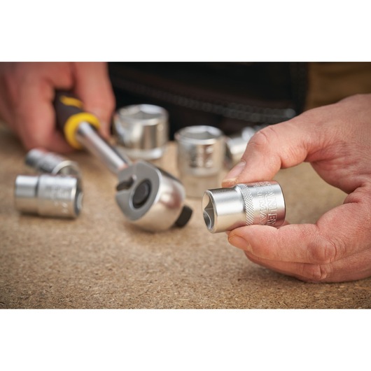 STANLEY FMMT17230-0 photography of chrome socket with ratchet handle on workbench, hand holding socket.