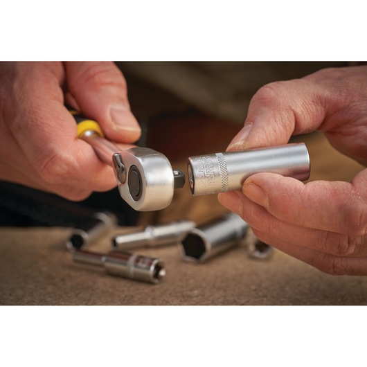 Photo of STANLEY FMMT17337-0 socket wrench and socket in hand, with sockets on work surface, close-up.