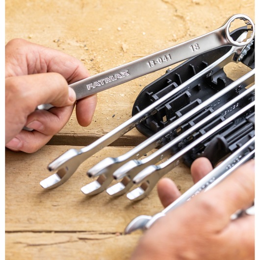 STANLEY FMMT82848-0 combination wrench set with metal wrenches in a plastic holder, hands holding a wrench.