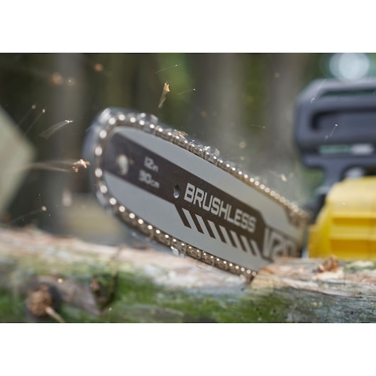 STANLEY SFMCCS730B chainsaw cutting wood, close-up showing brushless chain and yellow housing.