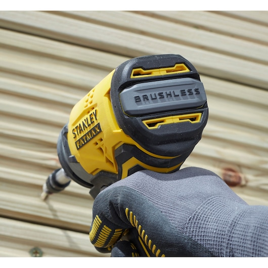 STANLEY SFMCF810D2K impact driver with brushless motor, close-up view, held by gloved hand against wood.