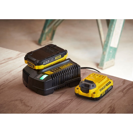 STANLEY SFMCF820D2K battery charger and battery pack on wooden surface, photography angle from above.