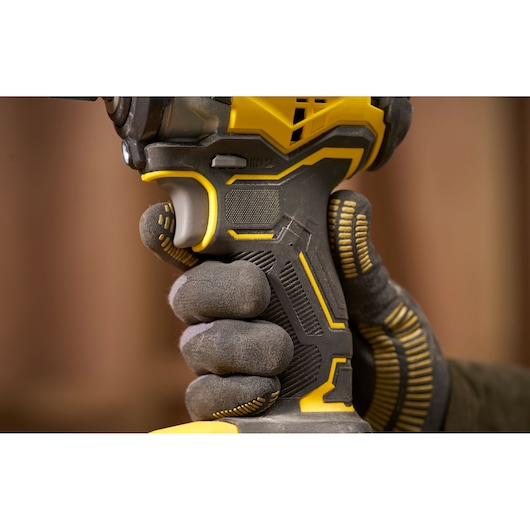 STANLEY SFMCF910B impact driver close-up showing ergonomic black and yellow grip held by a gloved hand.