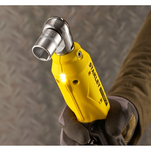 STANLEY SFMCF930B yellow cordless angle wrench tool with LED light held by gloved hand, close-up.