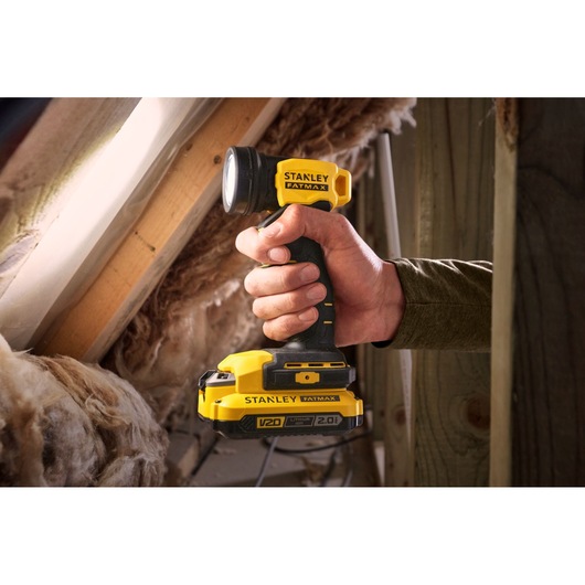 Photo of STANLEY SFMCL020B cordless yellow and black work light held in hand, shown in attic setting.