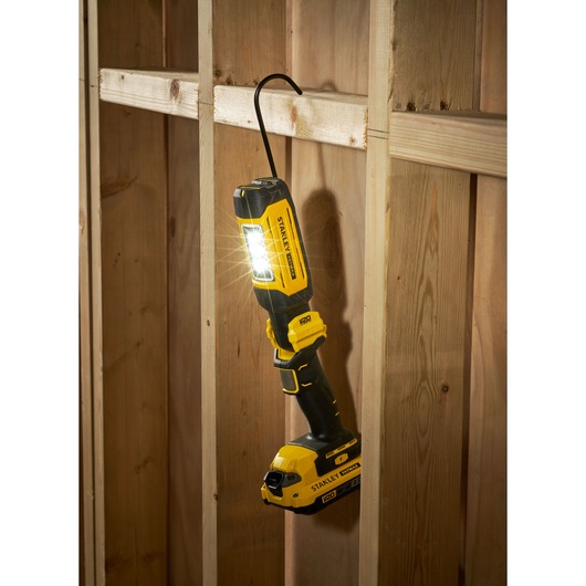 STANLEY SFMCL050B 18V STANLEY FATMAX V20 pivot light hanging on wooden frame, LED lit, black and yellow design.