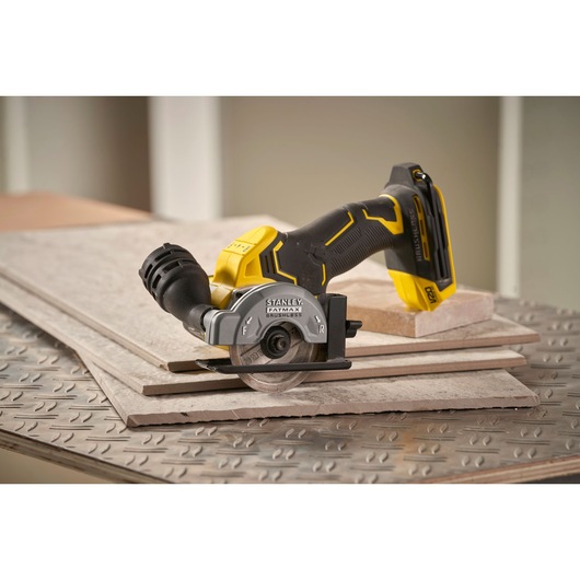 STANLEY SFMCM300B cordless circular saw on tiles, side angle, black and yellow design.