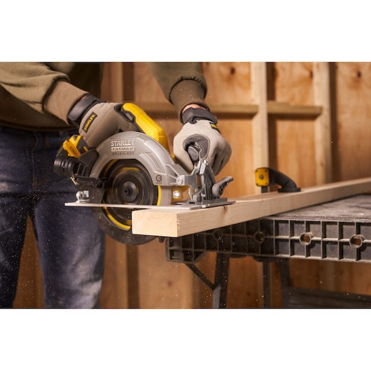 STANLEY SFMCS550B circular saw in use cutting wood, close-up in workshop setting.