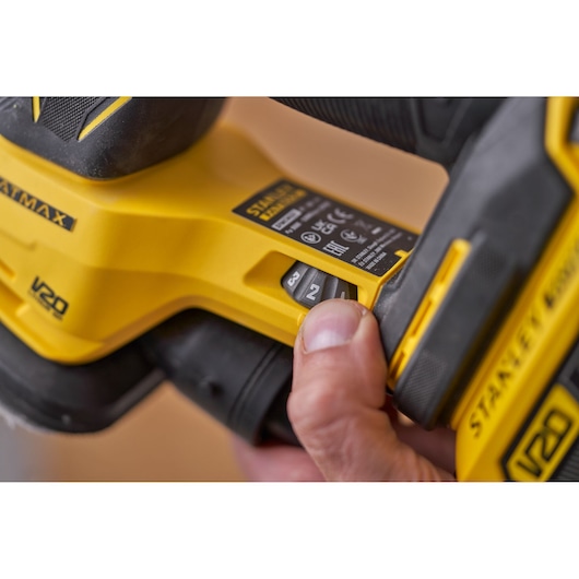 Photo of STANLEY SFMCW221D1S sander, close-up of speed control switch and yellow-black casing.