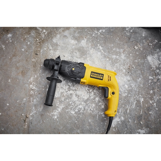 STANLEY SFMEH200K yellow and black corded hammer drill with side handle on concrete.